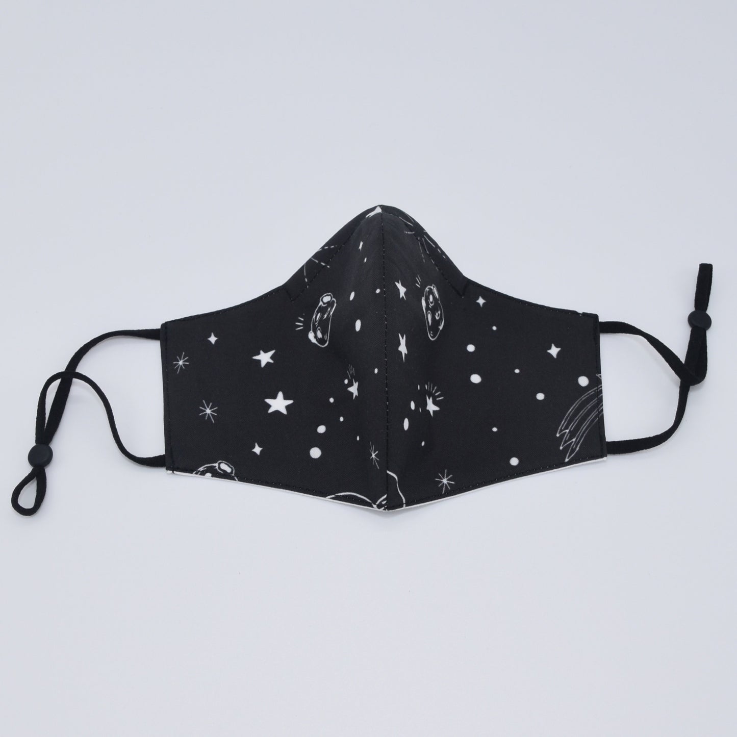 This black space print reversible face mask is made with one of our heavier-weight cotton novelty fabrics to provide a sturdier outer shell and the ultimate combination of both structure and comfort. Reversible and double-layered. Built with an adjustable nose bridge and adjustable ear straps.