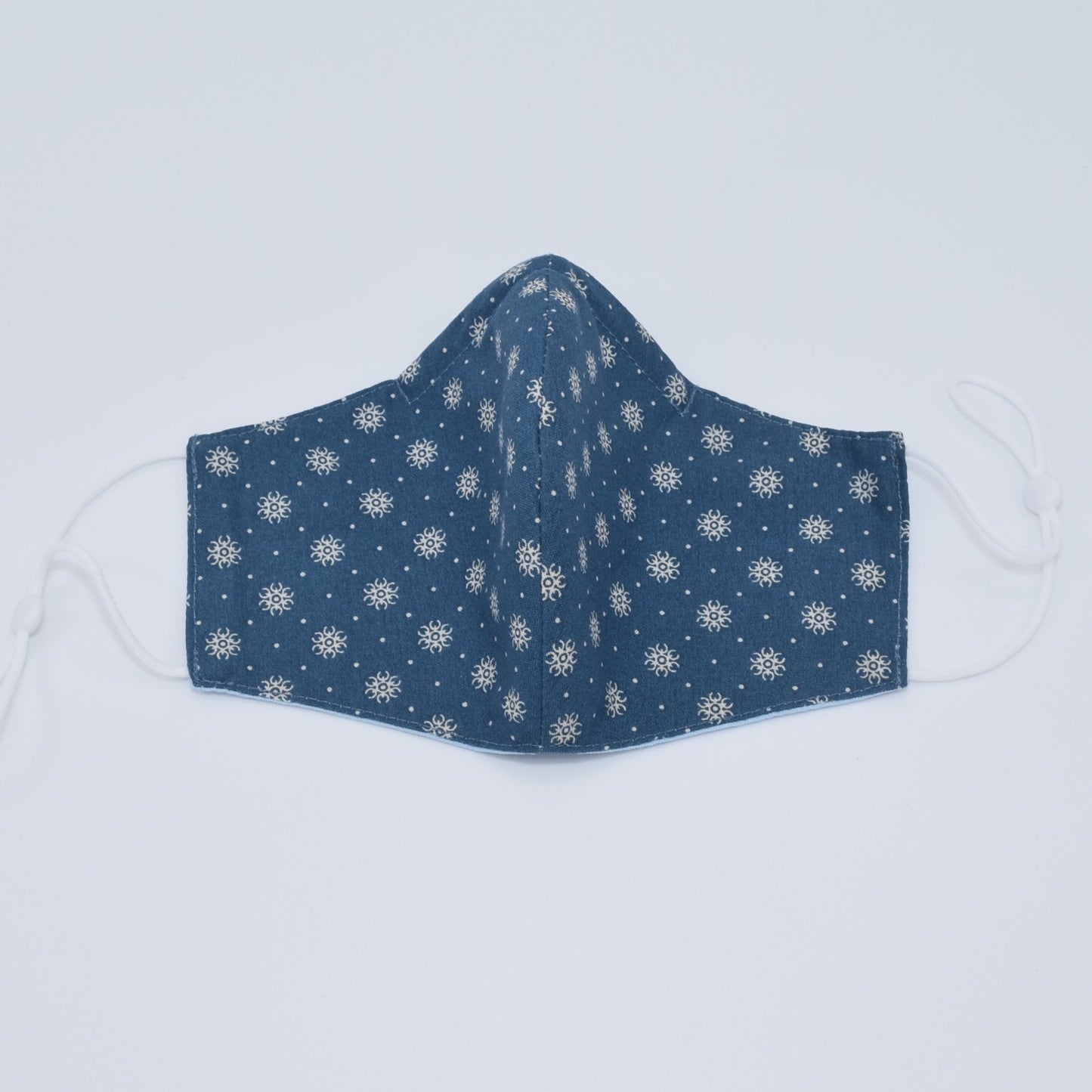 This dotted flowers on blue print face mask is reversible and double-layered. Built for comfort with an adjustable nose bridge and adjustable ear straps.