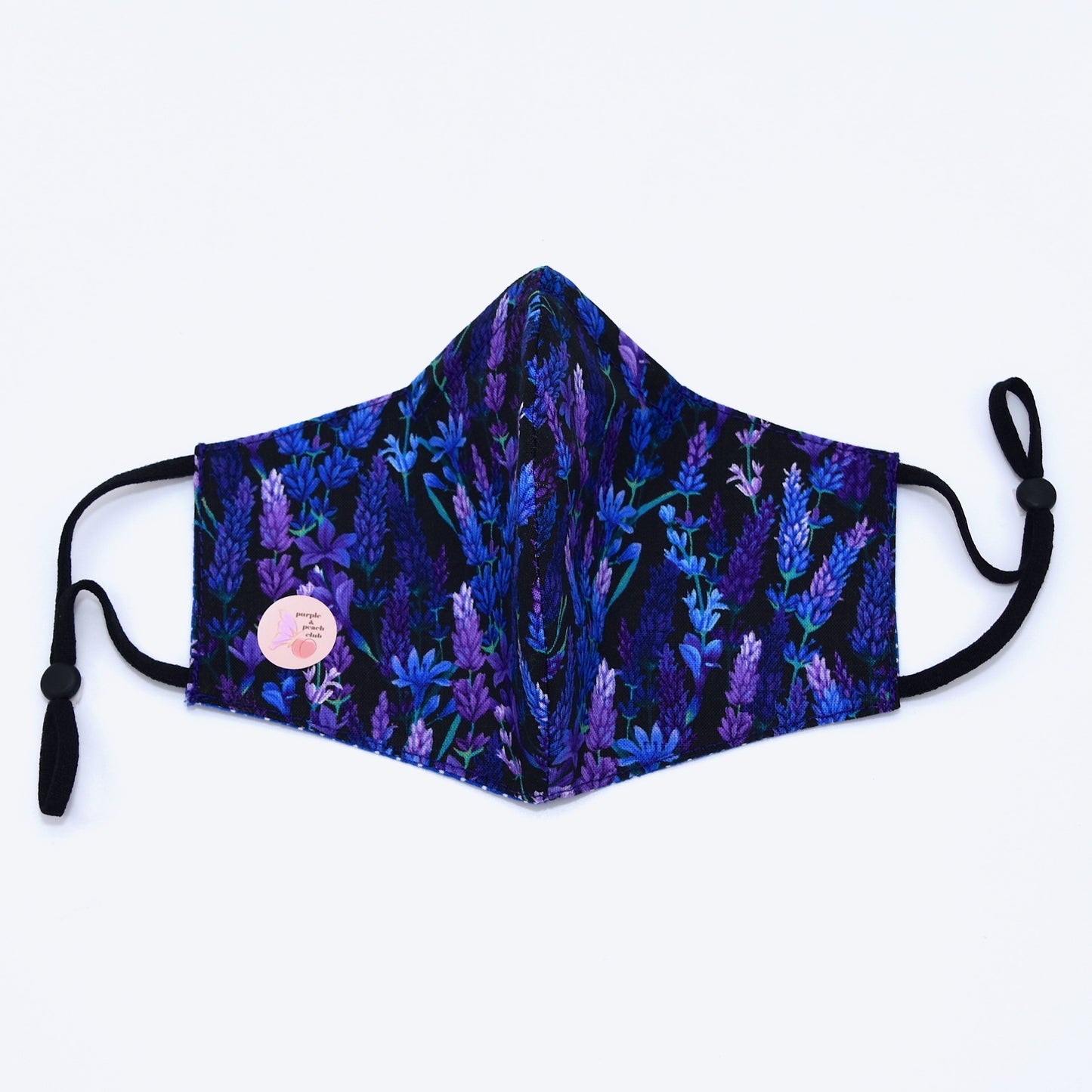 This lavender print cotton face mask is reversible and double-layered. Built with an adjustable nose bridge and adjustable ear straps.