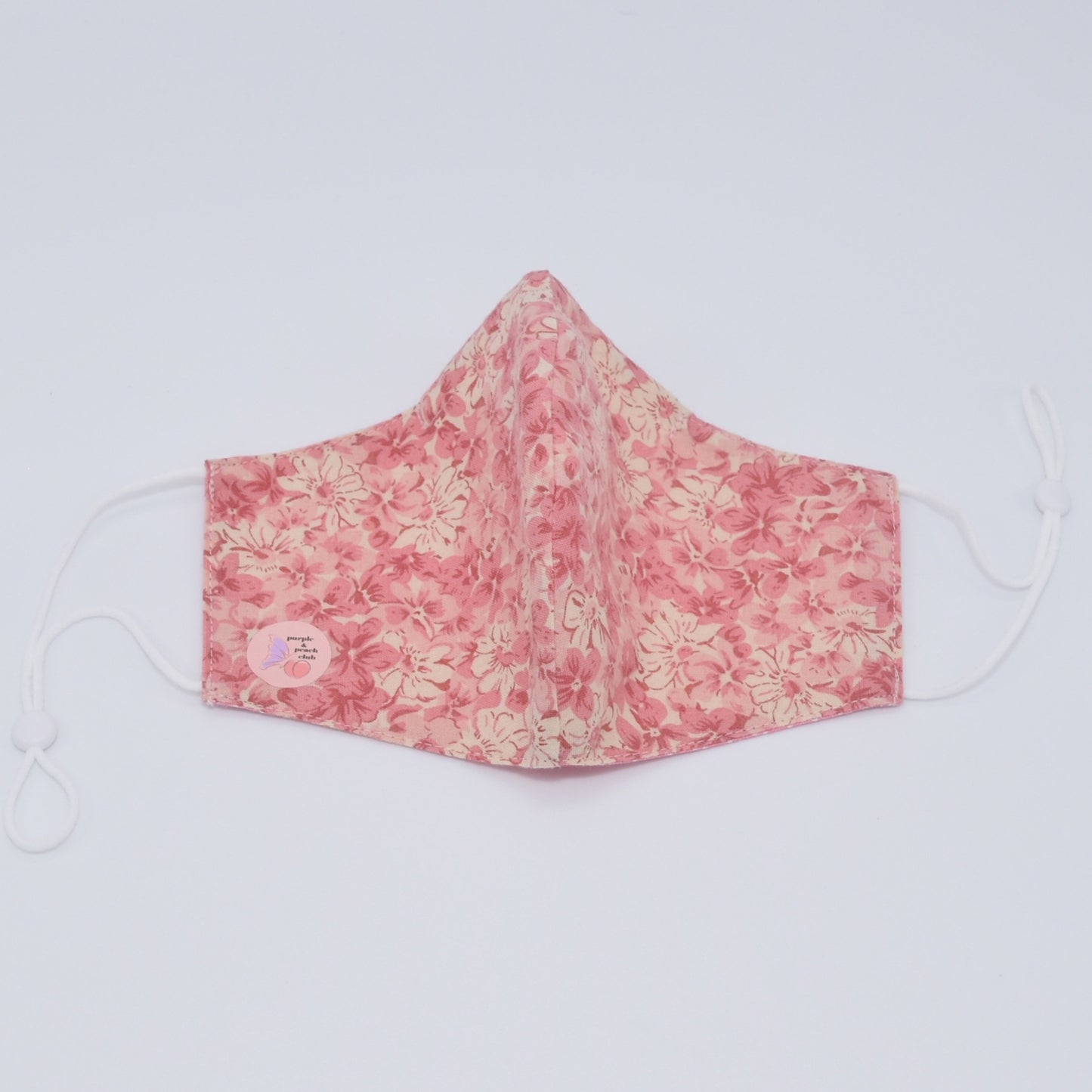 Featuring a soft pink floral design, the delicate elegance of this mask makes for a graceful and unique accessory, perfect for a formal setting. Reversible and double-layered. Built for comfort with an adjustable nose bridge and adjustable ear straps.