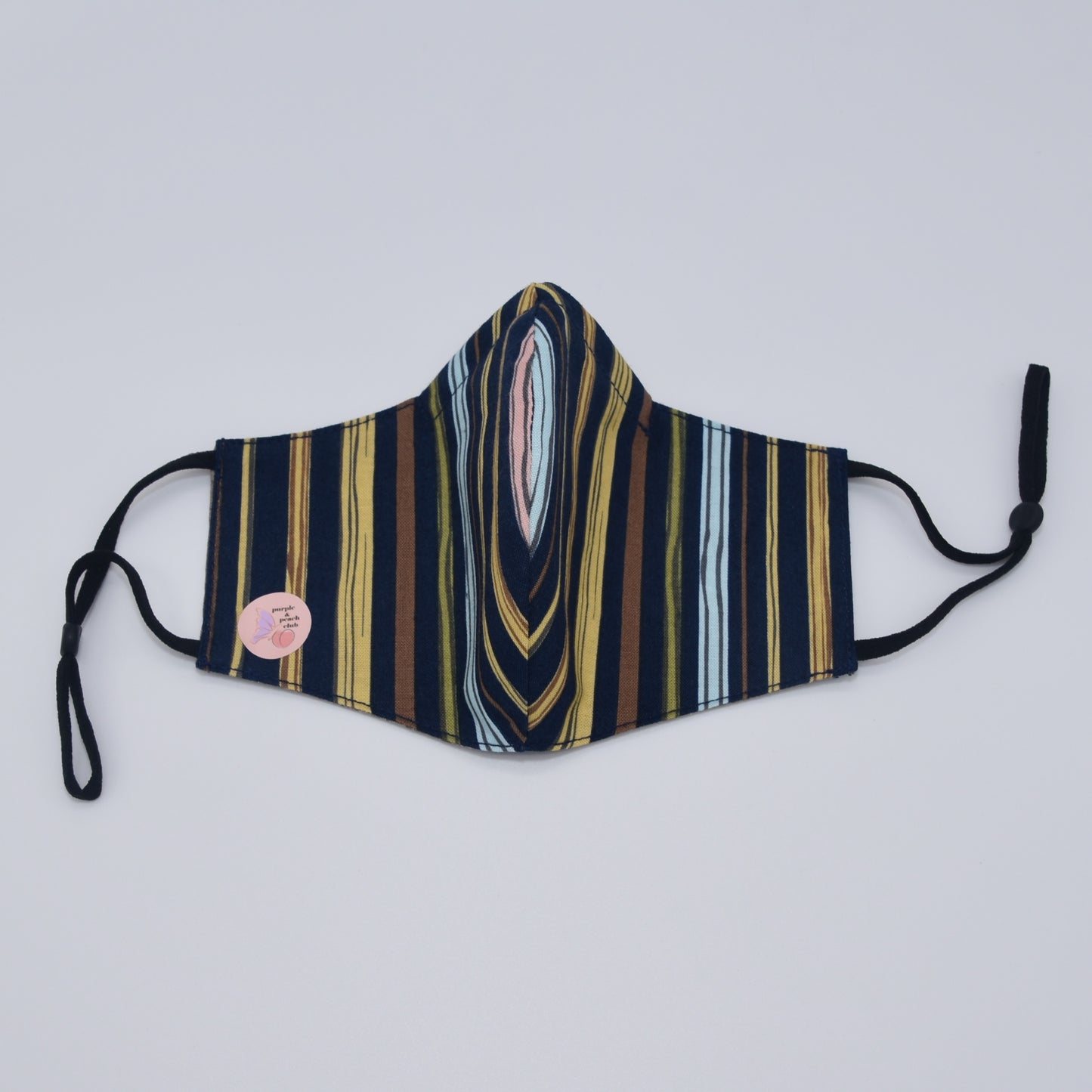 Deep and contrasting colors come together to form a striking look in this exquisite striped cotton mask. Reversible and double-layered. Built for comfort with an adjustable nose bridge and adjustable ear straps.