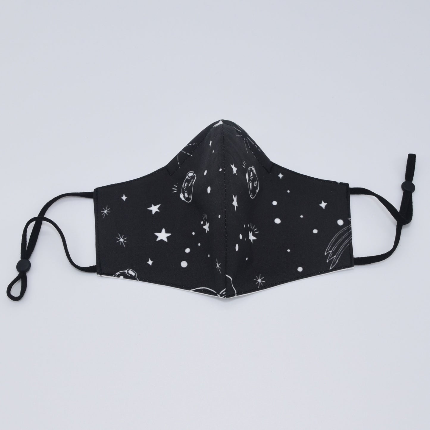 This black space print reversible face mask is made with one of our heavier-weight cotton novelty fabrics to provide a sturdier outer shell and the ultimate combination of both structure and comfort. Reversible and double-layered. Built with an adjustable nose bridge and adjustable ear straps. 