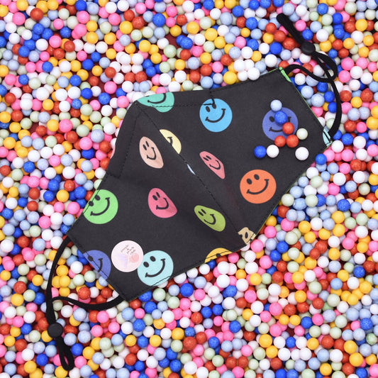 This happy faces print reversible face mask is made with one of our heavier-weight cotton novelty fabrics to provide a sturdier outer shell and the ultimate combination of both structure and comfort. Reversible and double-layered. Built with an adjustable nose bridge and adjustable ear straps. 