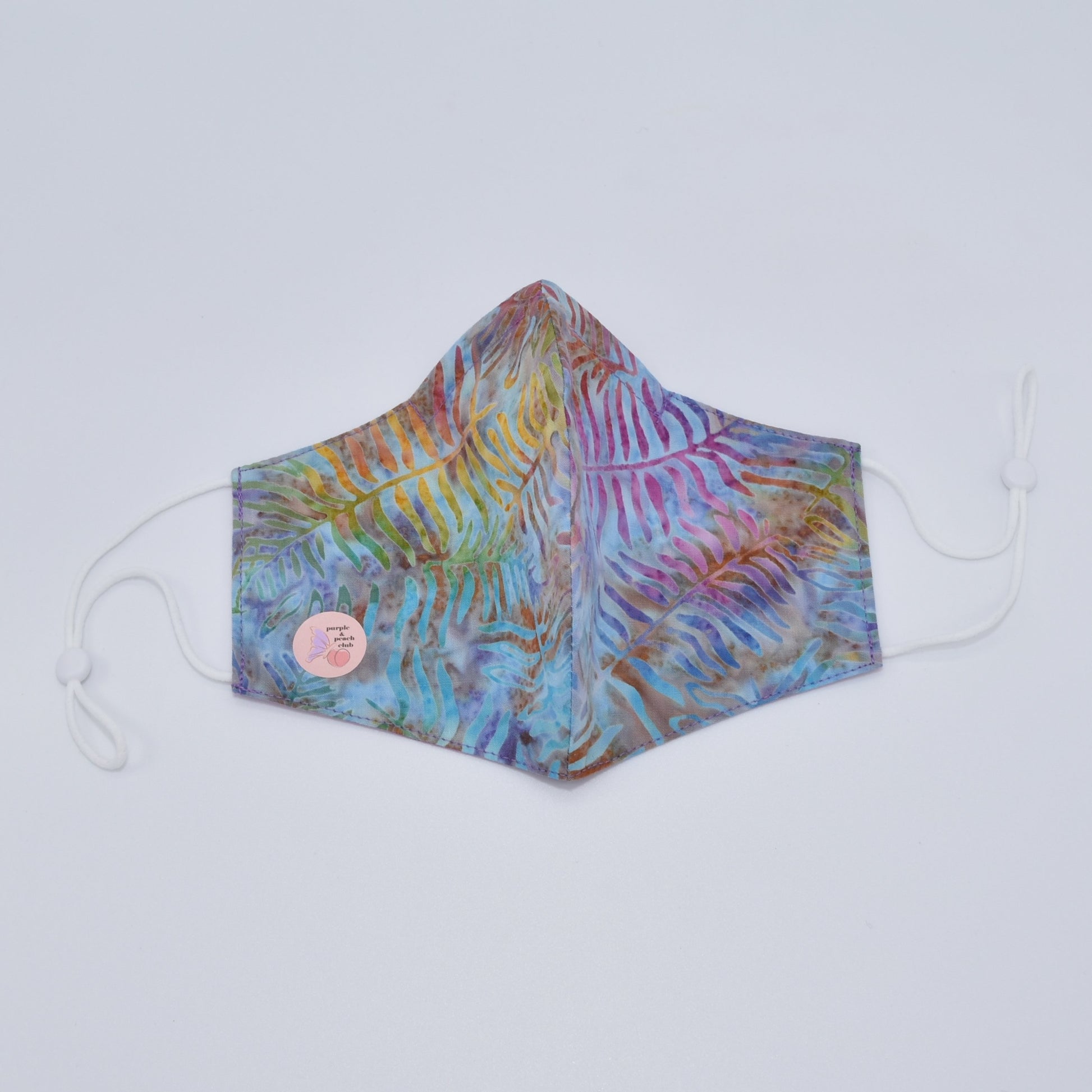 This leaf tie-dye print cotton mask is reversible and double-layered, built for comfort with an adjustable nose bridge and adjustable ear straps. 